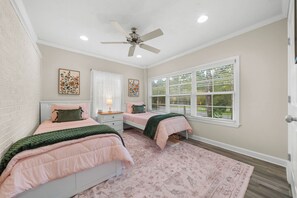 A bedroom with two beds, a ceiling fan, a window with blinds, and a decorative rug. - Get After that Azalea Walk to Georgia Southern (Statesboro)