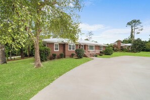 A two-story brick house with a front porch and a driveway. - Get After that Azalea Walk to Georgia Southern (Statesboro)