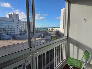Un balcó amb vista a un paisatge urbà, amb edificis i un cel serè.