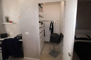 A bedroom with a bed, a desk, a chair, a wardrobe, and a small shelf with items. - Luxury Two-Room Apartment - Open Concept (Cologno Monzese)