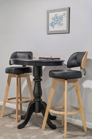 Een eettafel met twee stoelen, een inlijsting kaart aan de muur en een vloerbedekking.