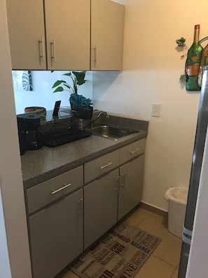 A compact kitchen with a sink, cabinets, and a countertop. - Best Location, Condado Studio, Beach Access (San Juan)