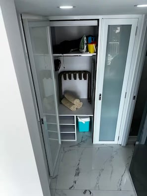 A walk-in closet with a built-in bench, shelves, and storage bins. - Aqua Luxury Modern Beach Apartment (Carolina)
