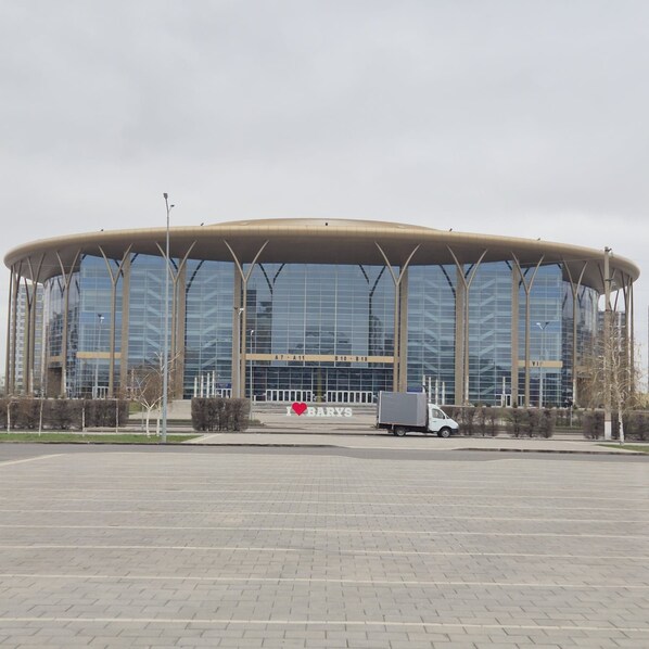 A large, modern building with a curved roof and a glass facade.