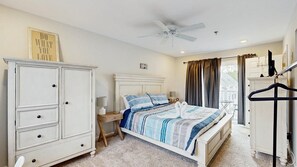 A bedroom with a bed, a wardrobe, a nightstand, a ceiling fan, and a window with curtains. - Beach Club - 20981 Coastal Hwy #4 (Rehoboth Beach)