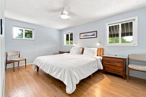 A bedroom with a bed, two nightstands, a chair, a ceiling fan, and windows. - Relaxed 4BR Boulder Home Near CU & Mountains (Boulder)