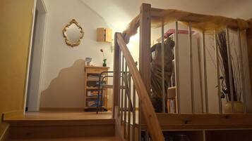 Un escalier en bois avec une rampe métallique menant à un palier.
