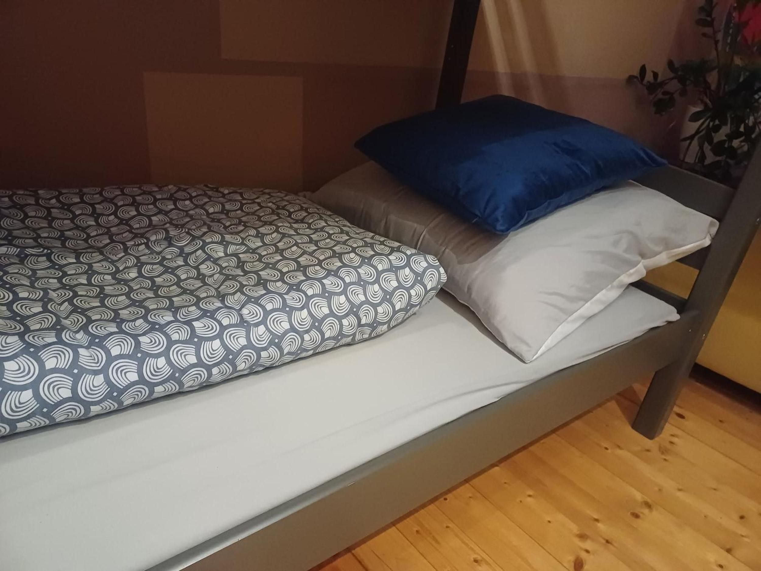 Ein Stockbett mit gemusterten Bettwäsche und Kissen.