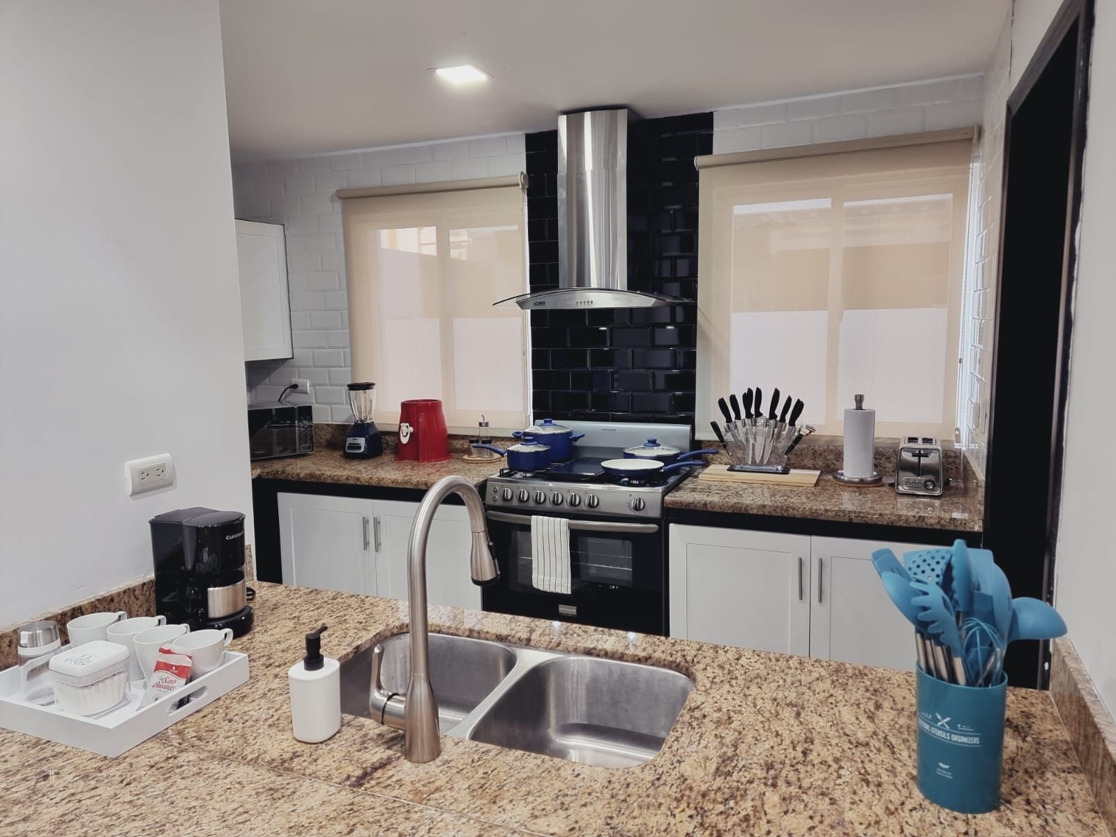 A modern kitchen with granite countertops, stainless steel appliances, and a double sink.