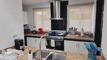A modern kitchen with granite countertops, stainless steel appliances, and a double sink.