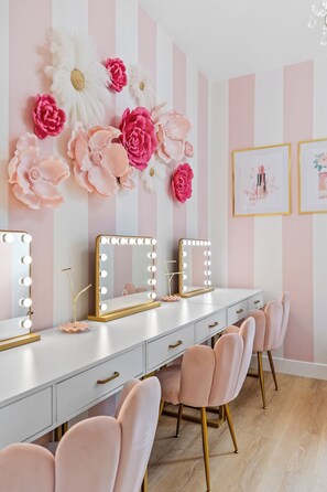 A vanity with mirrors and lights, a white dresser, and pink chairs. - Flagstaff Barbie House - 2 King Suites & Fire Pit, Hot Tub (Flagstaff)