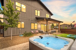 A modern house with a covered patio, a hot tub, and outdoor seating. - Flagstaff Barbie House - 2 King Suites & Fire Pit, Hot Tub (Flagstaff)