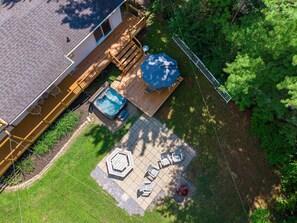 A residential backyard with a hot tub, patio furniture, and a wooden deck. - HAMAC | Spa & Lake Access in Dunham (Dunham)