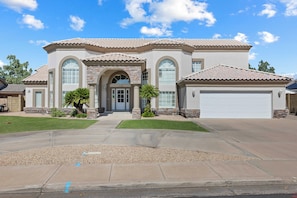 A two-story house with a stone facade, large arched windows, and a tiled roof. - Mesa Resort • 6BR • Pool + Slide • Spa • Pickleball • Theater (Mesa)