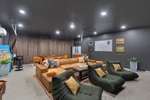 A modern living room with a sectional sofa, a coffee table, and a dining area with a table and chairs. - Mesa Resort • 6BR • Pool + Slide • Spa • Pickleball • Theater (Mesa)