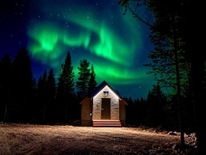A cabin with a simple design, a front door, and a small porch.