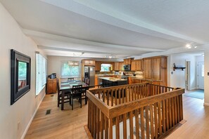 Eine geräumige Küche mit Holzausstattung, einem Essbereich und einer Holztreppe.