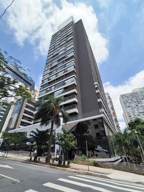 A modern high-rise building with multiple balconies and a pedestrian walkway. - Vrbo Property (São Paulo)