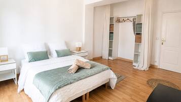 Une chambre à coucher avec un lit, des tables de chevet, une armoire et une porte.