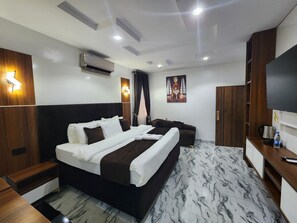 A hotel room with a bed, a TV, a desk, and a wardrobe.