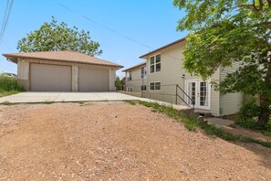 A two-story house with a garage, a front yard, and a tree. - Pet Friendly Game Room Westside Retreat Near Garden of Gods Walk 3blks to OCC (Colorado Springs)