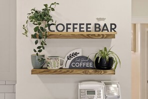 Et tekøkken med kaffabar, inklusiv kaffemaskine, krus og pynt.