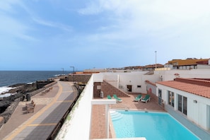 A rooftop pool area with a view of the sea, a staircase, and a few lounge chairs. - Home2Book Beachfront Pool House La Garita (La Garita)