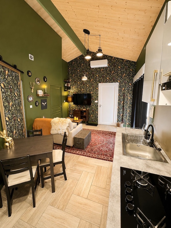 Una cocina compacta con comedor, televisor y chimenea.