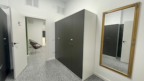 A hallway with a mirrored wardrobe, a chair, and a door with a sign. - UWANT HOSTEL UP (Sant Vicent del Raspeig)
