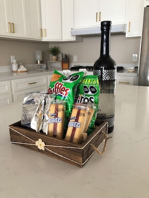 A kitchen counter with a wooden box containing snacks, a bottle of olive oil, and a bag of chips. - Marvelous 4-bedroom house in Playas de Rosarito perfect for families. (Playas de Rosarito)