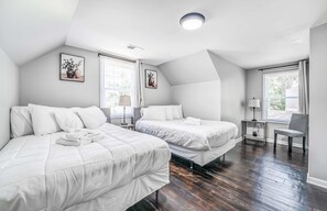 Une chambre avec deux lits, un bureau et une chaise.