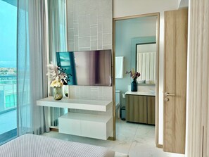 Une salle de bain moderne avec un grand miroir, des toilettes et un lavabo.
