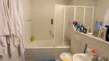 Une salle de bain avec une baignoire, des toilettes, un lavabo et un miroir.