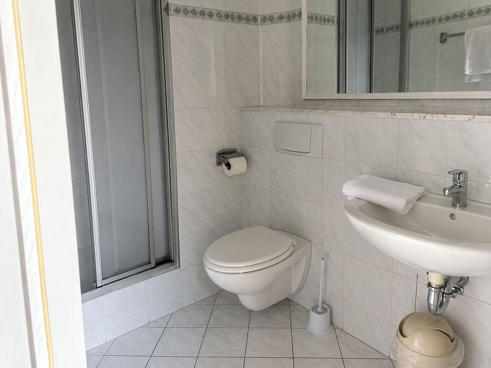 Une salle de bain comprenant des toilettes, un lavabo et un espace douche.