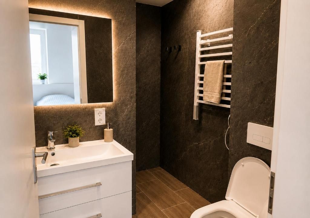 Ein Badezimmer mit einem weißen Waschbecken, Spiegel und WC.