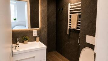 Ein Badezimmer mit einem weißen Waschbecken, Spiegel und WC.