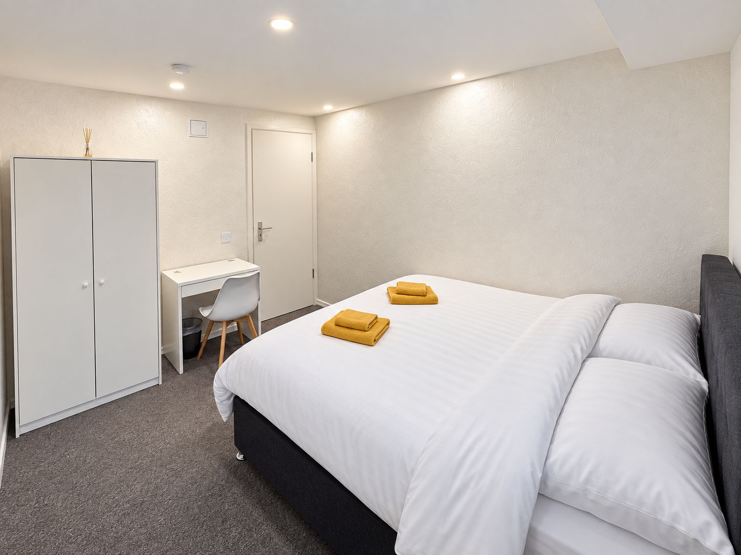 Una habitación de hotel con cama, escritorio y armario.