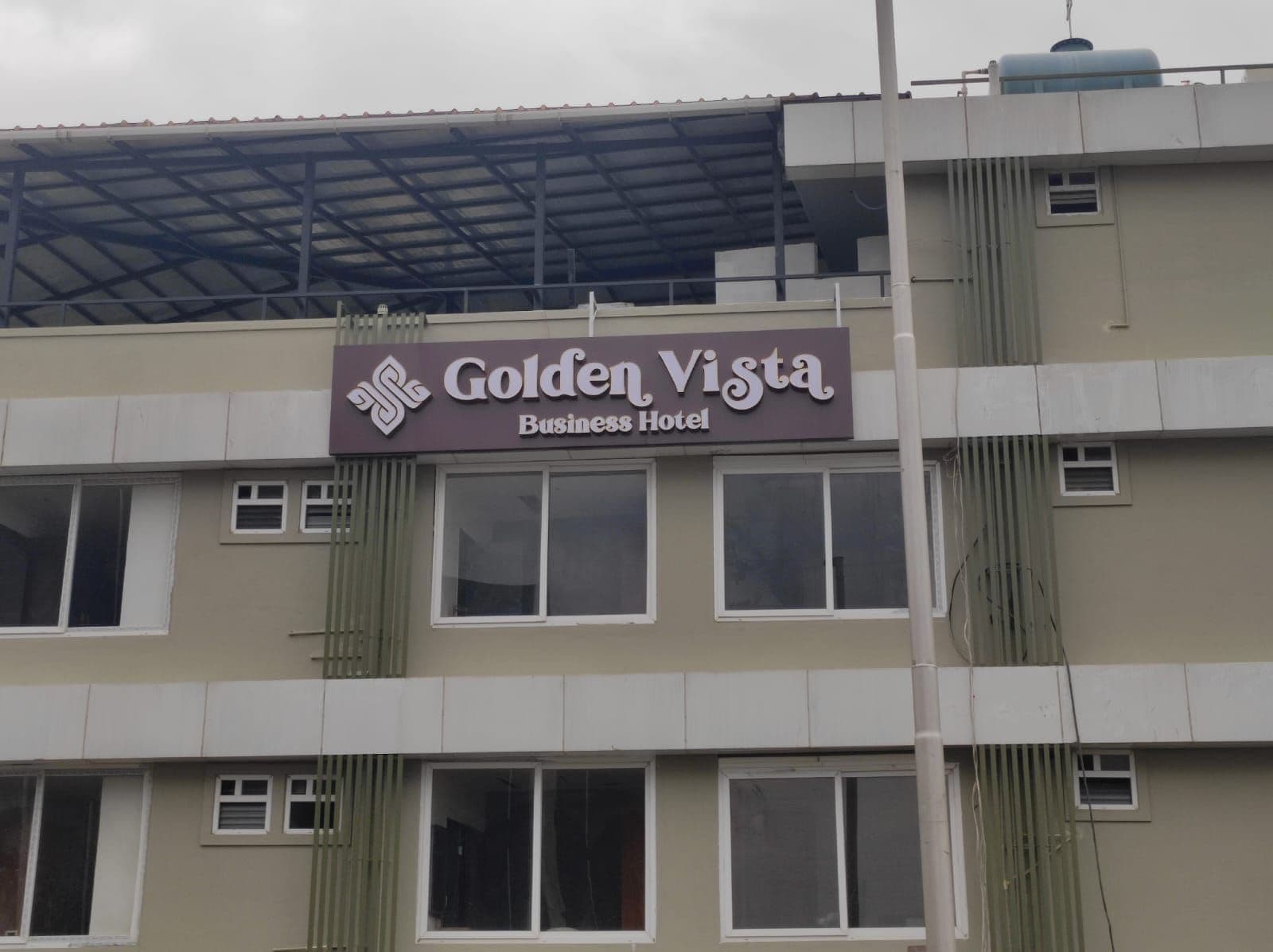 A building with a sign for 'Golden Vista Business Hotel'.
