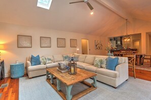 A spacious living room with a large sectional sofa, a wooden coffee table, and a ceiling fan. - Renovated Sea Pines Retreat with Private Pool (Hilton Head Island)