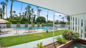 A backyard with a swimming pool, lounge chairs, and palm trees. - Desert Days Studio | Pool + Private Patio (Palm Springs)