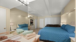 A bedroom with a bed, a desk, a mirror, and a television. - Desert Dreamin’ Studio | King Bed + Pool (Palm Springs)
