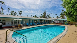 A swimming pool with lounge chairs and a covered seating area. - Desert Dreamin’ Studio | King Bed + Pool (Palm Springs)