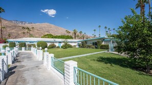 A motel with a front lawn, palm trees, and a mountain backdrop. - Desert Dreamin’ Studio | King Bed + Pool (Palm Springs)