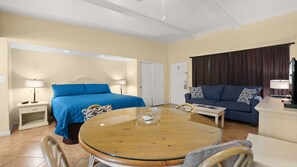 Ein Hotelzimmer mit Bett, Sofa, Esstisch und Fernseher.