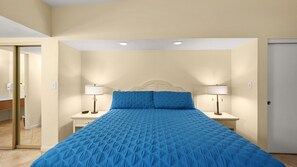 Ein Schlafzimmer mit einem Bett, zwei Nachttischlampen und einer Tür.