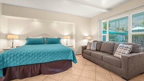 A bedroom with a bed, nightstands, a sofa, and large windows. - Sunshine State of Mind | Palm Springs Studio (Palm Springs)