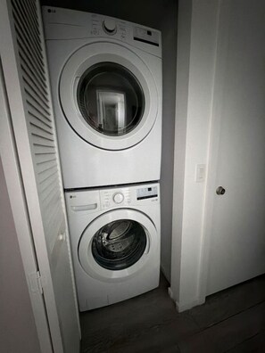 A stacked washer and dryer unit in a hallway. - Luxury Skyline Studio in Downtown Miami (Miami)