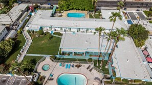 A multi-story hotel with a rooftop pool, a covered outdoor area, and a landscaped courtyard. - Palm Springs Bliss in a Studio Retreat (Palm Springs)