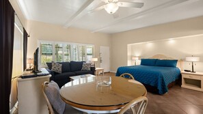 A hotel room with a bed, a sofa, a table, and a ceiling fan. - Palm Springs Bliss in a Studio Retreat (Palm Springs)
