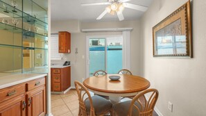 A dining area with a round table, chairs, and a ceiling fan. - 1 Bedroom for Palm Springs Adventures (Palm Springs)